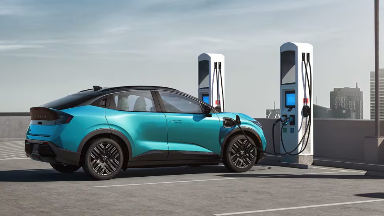 vue latérale arrière d'un Nissan Leaf 2026 branché à une borne de recharge