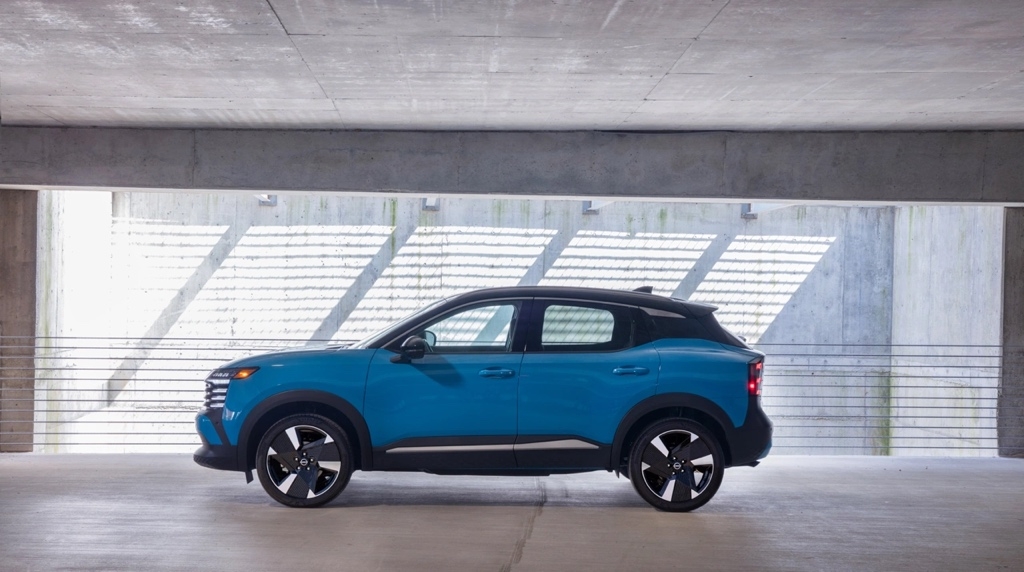 Nissan Kicks 2026 bleu en vue latérale stationné dans un garage moderne, un VUS sous-compact au design audacieux et pratique.